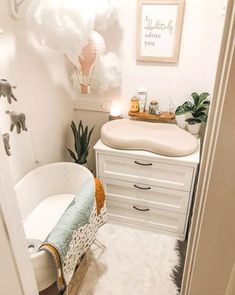 a baby's bathroom with an elephant themed rug on the floor and white furniture