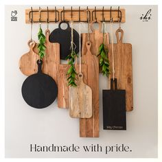 cutting boards hanging on the wall with plants growing out of them and an ad for handmade with pride