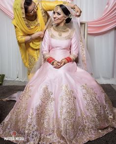 a man helping a woman put on her wedding dress