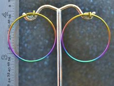 "These niobium 1 1/8\" (29 mm) Hoop Earrings are hand-forged. They are made by winding 1/2 hard 18 gauge (1.024 mm) round niobium wire on a mandrel. They are then given the catch loop, filed and polished. I then anodize them. This style of hoop is often referred to as a \"sleeper\" hoop because they are small and will lay somewhat flatter against the head than a post earring will. Please allow for some handmade variation. These are light and comfortable to wear. I sell them by the pair. Please s Hypoallergenic Rainbow Hoop Earrings As Gift, Rainbow Hypoallergenic Hoop Earrings, Hypoallergenic Rainbow Hoop Earrings, Adjustable Rainbow Hoop Earrings With Ear Wire, Small Rainbow Hoop Earrings For Pierced Ears, Rainbow Hoop Earrings With Ear Wire, Small Multicolor Hypoallergenic Hoop Earrings, The Catch, A Color