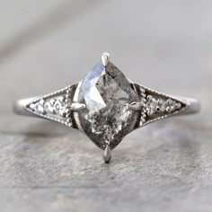 an old fashioned engagement ring with a pear shaped diamond