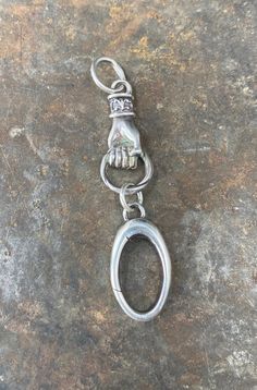 a metal keychain with a hand on it