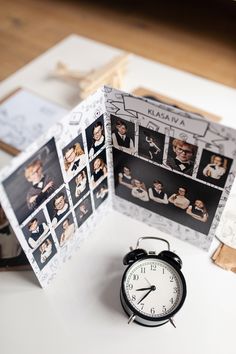 an alarm clock sitting on top of a table next to a card with pictures of people