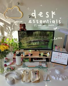 a desktop computer sitting on top of a desk next to a vase filled with flowers