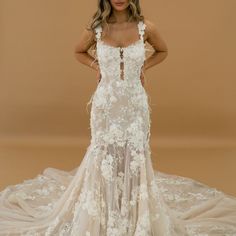 a woman in a wedding dress posing for the camera with her hands on her hips