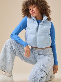 This vest features a cropped length, perfect for layering over your favorite tops. Ideal for transitional weather, it effortlessly adds a chic touch to any outfit. Light Blue Puffer Vest Outfit, Cropped Puffy Vest Outfit, Blue Vest Outfit, Crop Puffer Vest, Puffy Vest Outfit, Cropped Puffer Vest, Puffer Vest Outfit, Football Dress, Vest Fits