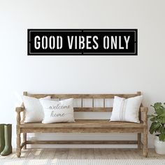 a wooden bench sitting in front of a wall with a sign that says good vibes only