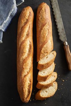 two loaves of bread next to a knife