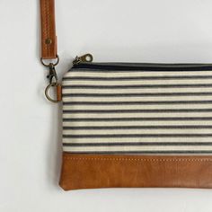 "This small crossbody bag for women is compact & lightweight while still offering plenty of room to carry essential items like your cash & bank cards, phone, and keys while you run errands or go out with friends. It's perfect for women who love a small bag, but also want to be hands-free. Use it as an every day handbag or travel bag and enjoy the ease of an adjustable strap that enables you to wear it crossbody or over-the-shoulder.  SIZE:  9\" wide x 6\" high, crossbody strap is adjustable up to 50\" long Features -  * exterior is made with designer cotton canvas in black & ivory ticking stripe and caramel brown vegan leather  * interfaced to give it structure and durability * detachable crossbody strap in matching vegan leather * interior lining is made using coordinating cotton in black Crossbody Zipper Pouch For Travel, Daily Use Crossbody Coin Purse With Zipper Closure, Daily Use Crossbody Coin Purse With Zipper, Everyday Crossbody Wallet With Zipper Pouch, Daily Crossbody Coin Purse With Zipper, Travel Crossbody Pouch, Crossbody Coin Purse With Zipper, Crossbody Travel Pouch, Crossbody Pouch With Adjustable Strap For Gift