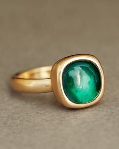 Juicy green lab grown emerald solitaire 18k yellow gold ring sits on top a solid 18k yellow gold wedding band. The Sovereign ring and the Essential Band by George Rings. Emerald Cabochon, Luxury Jewelry Brands, Colombian Emeralds, Emerald Ring, Bright Green, Cushion Cut, Custom Engraving, Statement Ring, Jewelry Branding