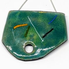 This Handcrafted Pendant Is Copper Formed And Then Enameled With Multiple Layers Of Vitreous Enamel Requiring A Kiln Firing After Each Layer. The Result Is A Beautiful Green/ Blue With The Lines Of White, Black, Yellow, Blue And Green. The Necklace Is Strung On A 20" Sterling Silver Chain. This Piece Is One Of A Kind And Brand New Without Tags. Green Enamel Pendant Necklace, Green Jewelry With Black Enamel As A Gift, Green Jewelry With Black Enamel For Gift, Green Enamel Jewelry With Black Enamel, Blue Enamel Round Pendant Necklace, Handmade Enamel Round Necklaces, Artisan Blue Hand Painted Necklaces, Artisan Hand Painted Blue Necklaces, Unique Blue Hand Painted Necklace