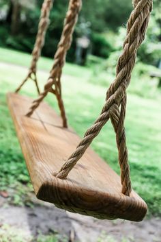 a wooden swing with rope hanging from it