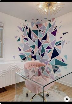 a pink chair sitting in front of a glass table