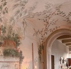 an ornately decorated living room with floral wallpaper and paintings on the walls,