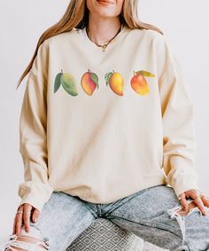 Add a burst of sunshine to your wardrobe with our Cozy Mango Sweatshirt! This vibrant, mango-colored sweatshirt is designed to keep you warm and stylish all season long. Crafted from a premium blend of soft cotton and durable polyester, it offers the perfect combination of comfort and longevity. 🌟Material🌟 Experience the softness of 100% ring-spun cotton which make strong and smooth fabric 🌟Size & Fit🌟 Offers a flattering fit for all body types. Please refer to our sizing chart to find your Relaxed Fit Orange Sweatshirt With Graphic Print, Orange Cotton Sweatshirt With Relaxed Fit, Orange Relaxed Fit Cotton Sweatshirt, Trendy Orange Relaxed Fit Sweatshirt, Mango Farm, Cottage Core Sweater, Aesthetic Fruit, Fruit Mango, Fruit Aesthetic