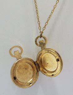 "Vintage 1928 brand pocket watch style locket pendant. 28\" chain with barrel fastener. Gold tone pocket watch style locket, including bale is 1 1/4\" x 3/4\". Hinged locket holds two photos. Gorgeous filigree design on the front of the locket & gold tone trim around the outer edge on the backside. This is in excellent vintage condition. Pre-owned & gorgeous! Signed with 1928 hang tag." Collectible Yellow Gold Pocket Watch With Locket, Antique Yellow Gold Pocket Watch With Locket, Gold Brass Pocket Watch With Antique Finish, Yellow Gold Pocket Watch With Locket For Collectors, Antique Brass Gold Pocket Watch, Gold Antique Finish Brass Pocket Watch, Vintage Necklaces With Adjustable Chain For Keepsake, Vintage Keepsake Necklace With Adjustable Chain, Vintage Bronze Pocket Watch With Antique Finish