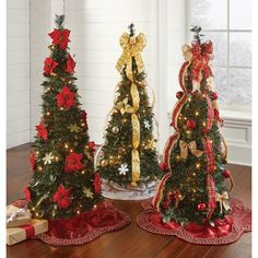 three small christmas trees with bows on them