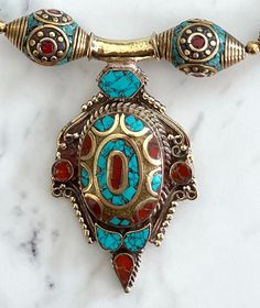 BerneyBeadShop original design Tibetan/Nepali brass pendant necklace. The pendant is inlaid with turquoise and coral, flanked by Tibetan/Nepali beads, turquoise, red jasper, and lapis lazuli semiprecious stone beads, brass and pewter findings, and finished with a lobster claw clasp. 21.5" end to end. Pendant is 2.75" drop. Traditional Turquoise Inlay Necklace As Gift, Traditional Turquoise Necklace With Inlay For Gift, Traditional Turquoise Pendant Necklace With Natural Stones, Jasper And Lapis, Brass Pendant Necklace, Style Tattoo, Turquoise And Coral, Red Jasper, Tattoo Inspo