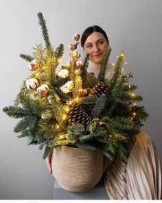 a woman holding a christmas tree in her hands