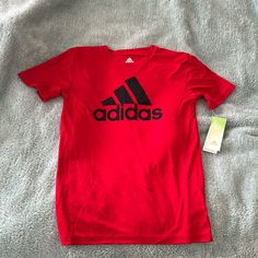 This 100% Polyester Red Adidas T-Shirt Size 10/12 Adidas Red Short Sleeve T-shirt, Adidas Red Crew Neck T-shirt, Red Adidas Crew Neck T-shirt, Red Adidas Short Sleeve T-shirt, Basic Red T-shirt With Logo Print, Adidas Red Sporty Top, Red Adidas Sporty Top, Sporty Red Adidas Top, Adidas University Red Short Sleeve Top