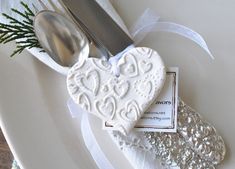 a heart shaped dish on a plate with a knife and spoon in the shape of a heart