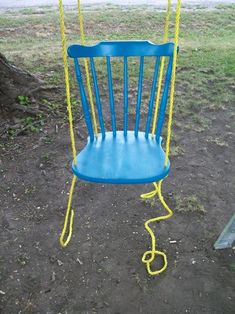 a blue and yellow swing set in the ground with ropes attached to it's back