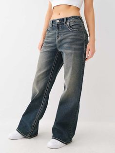 The Bobbi Big T Baggy Jean features a low-rise waist, zip fly, subtle fading, wide leg, and two-tone Big T stitching. Finished with horseshoe detailing on the back flap pockets and burnished hardware.    Style: 208451 Baggy True Religion Jeans, Baggy Jean, Painted Denim, Kids Denim, True Religion Jeans, Ripped Denim, Short Shirts, Plus Size Jeans, Pant Shirt