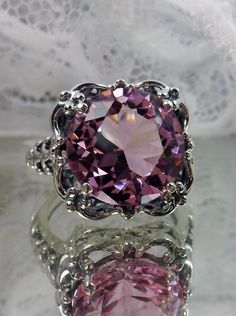 6ct. Simulated Pink Topaz Solid Sterling Silver RingSpeechless Design#D103 This filigree ring is a reproduction of a Victorian filigree antique setting set with a stunning 6ct. simulated Pink Topaz gemstone solitaire. This full cut round gem is 12mm in diameter. The inside of the band is marked 925 for solid sterling silver. Notice the beautiful bow and floral design of the silver filigree setting and band. This is a lovely rendition of an antique filigree ring. This large oval gemstone is wrap Victorian Filigree, Pink Topaz Ring, Vintage Jewelry Antique, Victorian Ring, Antique Filigree, Victorian Rings, Unusual Jewelry, Pink Topaz, Button Jewelry