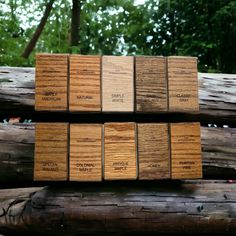 several pieces of wood stacked on top of each other in front of some green trees