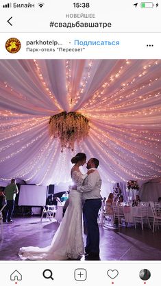 the bride and groom are sharing their first dance together in front of an overhead chandelier