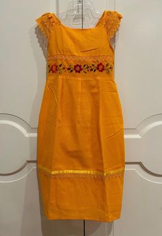 Perfect for any occasion, these hand embroidered Dress are unique and fun. Girls will love the bright colors and festive motifs featured on these cotton Dress. Each Dress is one of a kind. Made by Hand By  artisans from Mexico. Bohemian Style.  COLORS: yellow  with multicolor silk embroidery. APPROXIMATE MEASUREMENTS. Around bust 34" Shoulder to bottom hem 34" PC# C-850 Folk Cotton Dress With Resham Embroidery, Folk Cotton Dresses For Festivals, Bohemian Cotton Embroidered Dress For Festive Occasions, Festive Cotton Dress With Floral Embroidery, Fitted Cotton Embroidered Dress For Festivals, Folk-style Cotton Dress With Resham Embroidery, Folk Style Cotton Embroidered Dress With Resham Embroidery, Sleeveless Cotton Dress With Resham Embroidery, Festive Multicolor Embroidered Cotton Dress