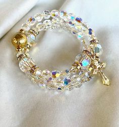 This beautiful Rosary wrap bracelet is a full 5-decade Rosary.  It was created with love using premium quality, genuine Austrian Swarovski crystals with AB coating that creates the brilliant, sparkled, rainbow-colored effects on each of the crystals.   The thousands of glitter are a result of their reflection of the light.  The lovely clear color exudes a sense of God's glory, sure to be appreciated during your spiritual contemplative prayer vigil, each crystal giving a tiny glimpse of Heaven's Catholic Rosary Bracelet, Contemplative Prayer, Beautiful Rosary, God's Glory, Decade Rosary, Catholic Rosary, Rosary Bracelet, Rosary Catholic, Memory Wire