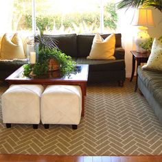 a living room with two couches and an umbrella in the middle of it's floor