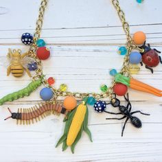 "Garden bug necklace filled with bright beads, insects and vegetable charms. Super fun and quirky necklace for insect lovers. Perfect garden lover gift.  18\"L with 3\" extension, Lenora Dame signature gold-plated cable chain with lobster clasp." Quirky Necklace, Bug Necklace, Garden Bugs, Garden Lover Gifts, Big Jewelry, Funky Earrings, Fun Jewelry, Perfect Garden, Crown Jewels