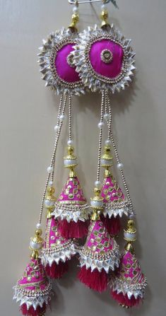 some pink and white ornaments hanging from a wall