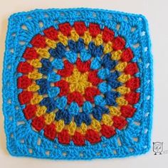 a crocheted square is shown in red, yellow and blue