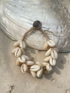 Introducing our new beach accessory: the OCEAN COWRIE SEASHELL BRACELET. Crafted with natural shells sourced from the depths of the ocean in Thailand, this statement piece beautifully captures the essence of the sea. Each shell is carefully combined to create a captivating and unique representation of oceanic beauty. Perfect for beach outfits, honeymoons, resort wear, or gift for your love ones, this choker necklace is a versatile addition to your wardrobe. What sets it apart is our commitment t Coastal Beach Bracelet Jewelry, Shell Jewelry For The Beach In Coastal Style, Bohemian Cowrie Shell Strand Bracelet, Beachy Shell Bracelet Jewelry, Bohemian Cowrie Shell Bracelet, Coastal Shell Jewelry For Vacation, Beach Shell Necklace Made Of Mother Of Pearl, Coastal Shell Jewelry For Beach Season, Cowrie Shell Beaded Bracelets As Gift