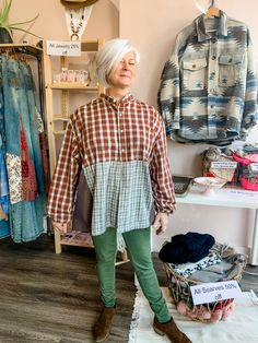 an older woman standing in front of some clothes