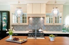 a kitchen with wooden counter tops and white cabinets in the center, surrounded by vases filled with flowers