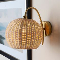 a wall light that is hanging on the side of a wall next to a framed photograph