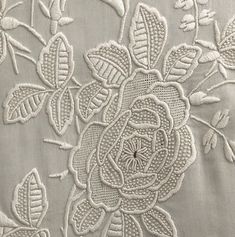 an embroidered fabric with flowers and leaves on it