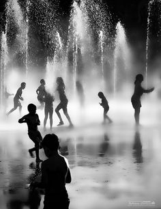 children playing in the water fountains at night