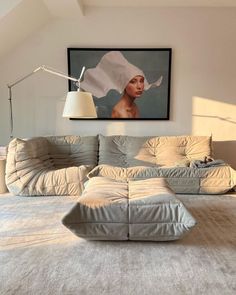 a living room filled with furniture and a painting on the wall above it's head