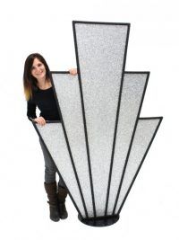 a woman standing behind a tall light fixture with her hands on the top of it