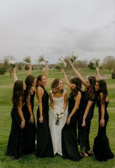 a group of women standing next to each other on top of a lush green field