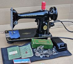 an old sewing machine sitting on top of a table next to some books and other items