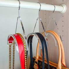 two purses are hanging from hooks on a coat rack with chains attached to them