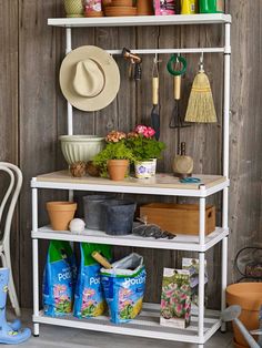 a white shelf with gardening tools and flowers