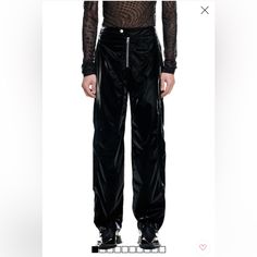 Mugler H&M. Relaxed-Fit, Biker-Style Pants In Woven Fabric With A Sheen And The Designer's Signature Twisted Seams At Front And Back. Extended Waistband Tab With Snap Fastener, Visible Zipper At Front, An Embossed Motif At Back With The Designer's Logo, And Side Pockets With Zipper. Gently Tapered Legs With Zipper At Hems. Lined. Composition Lining: Cupro 100%, Shell: Polyester 90%, Polyurethane 10% Fitted Black Cargo Pants With Zip Fly, Black Tapered Leg Bottoms With Zip Fly, Biker Pants With Belt Loops And Straight Leg, Edgy Parachute Pants, Black Biker Pants With Zip Fly, Edgy Wide Leg Pants With Zip Fly, Black Wide Leg Pants With Zip Fly, Edgy Trousers With Zip Fly, Black High Waist Biker Bottoms