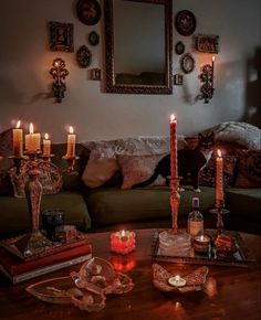 a living room filled with lots of candles on top of a wooden table next to a couch